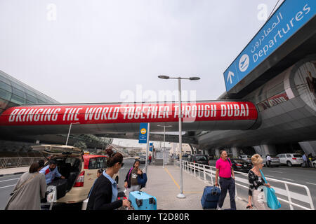 Les passagers qui quittent un taxi pour prendre un avion à l'Aéroport International de Dubaï, Émirats Arabes Unis Banque D'Images