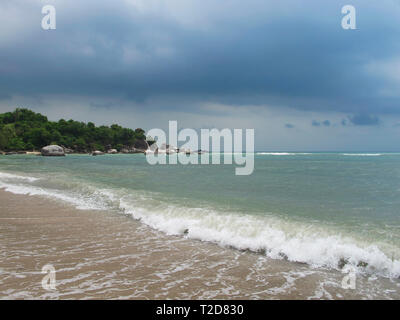 La mer turquoise et ciel bleu. Il y a de beaux nuages dans le ciel. Sur la côte de sable lisse. La mer est claire, visible des vagues. Carte postale pour le magazin Banque D'Images