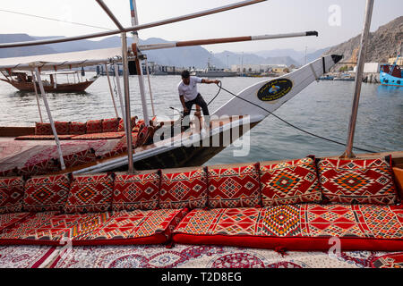 Bateau de croisière à bord d'un boutre arabe décoration traditionnelle bateau en bois le long des montagnes rocheuses de la péninsule de Musandam dans l'Oman Fjords Banque D'Images