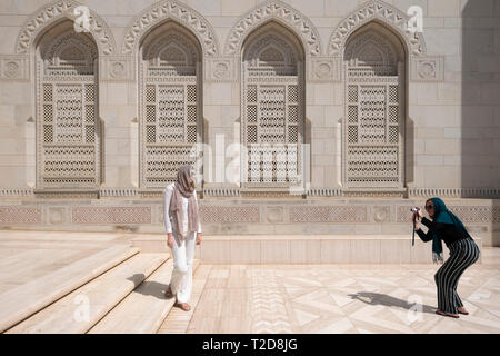 Tourist posant pour des photos à la Grande Mosquée Sultan Qaboos, Muscat, Oman Banque D'Images