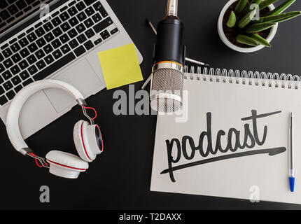 Concept d'enregistrement de podcast avec microphone, casque et un ordinateur portable à côté de l'application Notes sur le tableau noir Banque D'Images