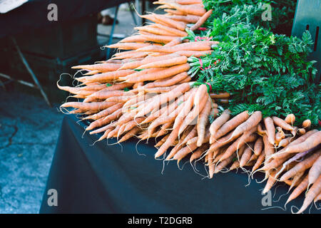Des centaines de produits frais et des carottes crues sont en train de vendre à un groupe à un marché de producteurs Banque D'Images