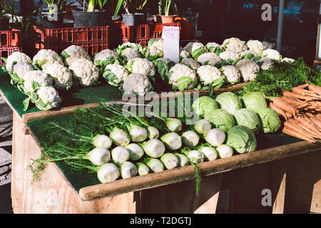 Éventail coloré de légumes pour la vente sur un stand en bois dans un marché de producteurs Banque D'Images