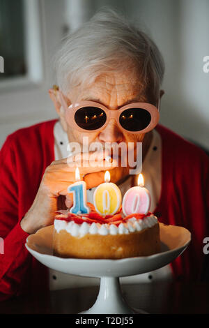 Happy Senior femme aux cheveux gris bien habillé fête son 100e anniversaire à la maison. Banque D'Images