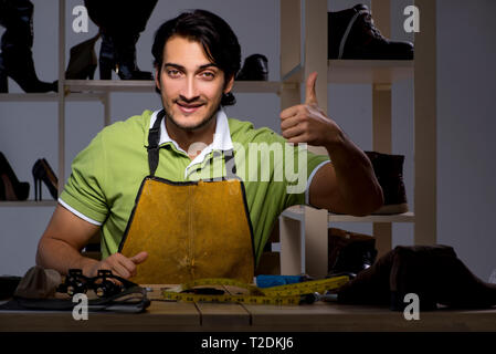 Les jeunes dans la nuit de l'atelier de cordonnier Banque D'Images