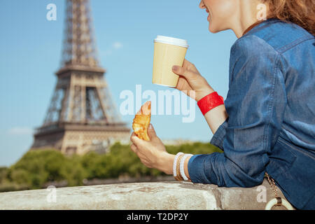 Libre à sourire voyageur individuel moderne la femme en bleu jeans ensemble il n'est pas loin de la tour Eiffel à Paris, La France ayant tasse à café et croissant. Banque D'Images