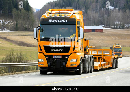 Salo, Finlande - le 29 mars 2019 : MAN TGX 41,640 chariot de Rantala Yhtiot tire Noteboom remorque sur route, sur l'arrière-plan Volvo FH de la même société. Banque D'Images