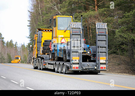 Salo, Finlande - le 29 mars 2019 : camion Volvo FH Jaune tire sur tracteur terminal Noteboom trailer en convoi avec un autre camion de la même société. Banque D'Images