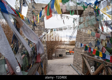 Une arche de pierre chemin menant sur un pont à Leh, Ladakh, couvert de drapeaux de prière Tibetains Banque D'Images