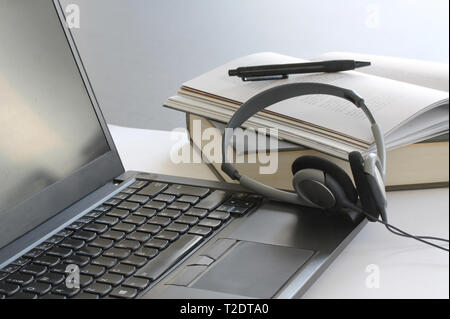 Ordinateur portable sur la table de travail avec des livres, des papiers, un crayon et un casque. Close up stock photo. Banque D'Images