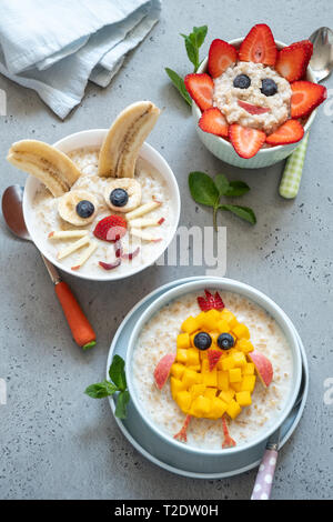 Bols drôles avec porridge avec bunny, chick et fleurs pour Pâques Banque D'Images
