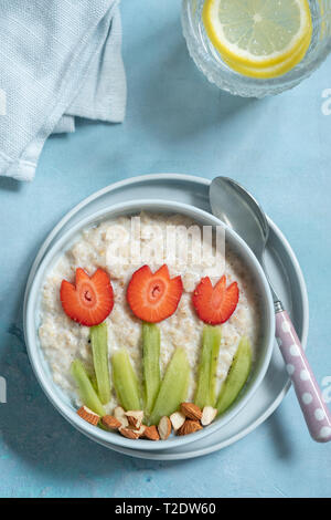 Drôle avec bols de porridge d'avoine avec fleurs de printemps Banque D'Images