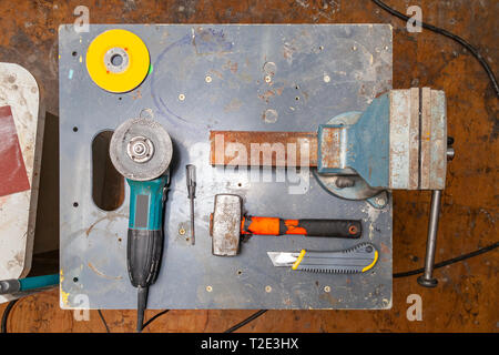 Mise à plat sur un établi avec un ensemble d'outils composée d'un grand vice, lourde meule d'angle, tournevis, cutter, masse, et une pièce de rechange cutti Banque D'Images