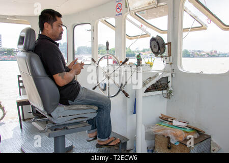 BANGKOK, THAÏLANDE, 23 novembre 2017, un capitaine est la conduite d'un bateau sur la rivière Chao Phraya à Bangkok. La timonerie sur un ferry en Thaïlande. Banque D'Images