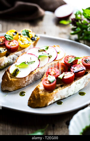 Bruschetta avec tomates cerises et radis à l'huile de basilic Banque D'Images