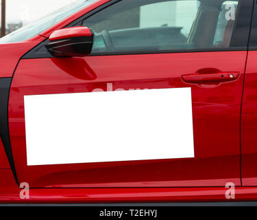 D'un coup horizontal blanc vierge signe magnétique sur une voiture rouge de la porte latérale. Banque D'Images