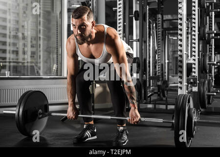 Bodybuilder barbu de l'exercice à la salle de sport se pencher maintenant hâte d'haltères motivés Banque D'Images
