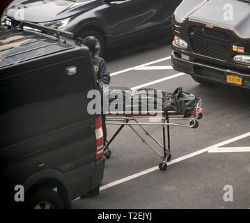 Les travailleurs de la NYC Bureau du médecin légiste en chef enlever une personne décédée d'un immeuble à New York le Mercredi, Mars 20, 2019. (Â© Richard B. Levine) Banque D'Images