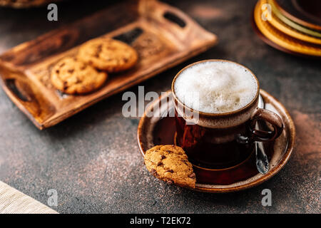 Cappuccino au Coffee cup avec les cookies sur fond rustique foncé Banque D'Images