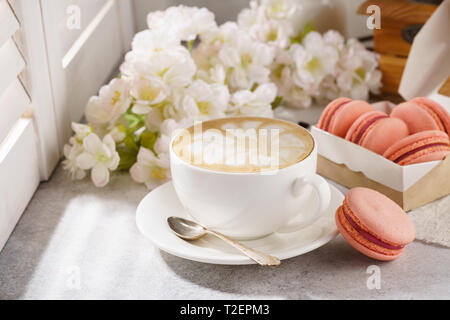 Tasse de café et macarons français. La lumière naturelle dans l'arrière-plan. Banque D'Images