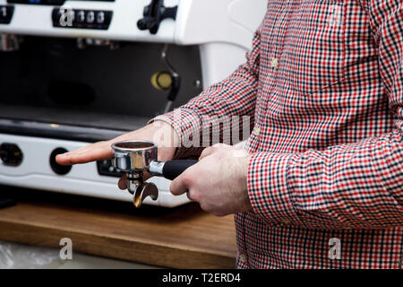 Beau jeune hipster barista faire le café pour ses clients dans le café. Banque D'Images