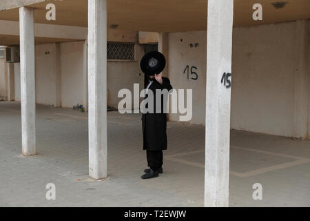 Un Juif orthodoxe ultra couvre son visage à la caméra dans Shechunat Yeelim (le bouquetin quartier) à Arad une ville dans le District sud d'Israël. Gur hasidim et juifs laïques à Arad ont été à couteaux tirés depuis des années. Accuser les résidents laïque Gur hasidim de tenter de prendre sur la ville et nuire à leur mode de vie, tandis que la population locale Gur soutiennent que la ville refuse de leur fournir des services municipaux de base. Banque D'Images