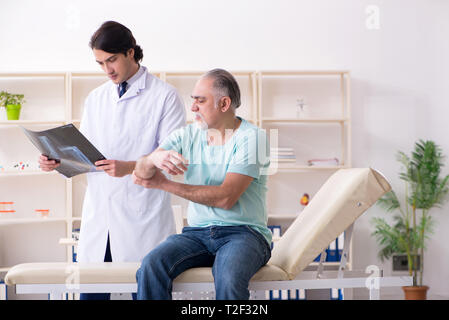 Vieil homme jeune homme médecin visite Banque D'Images