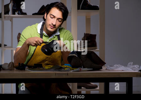 Les jeunes dans la nuit de l'atelier de cordonnier Banque D'Images