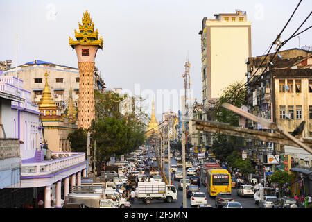 Vue de dessus, la circulation quotidienne et de la vie dans les rues de Yangon au coucher du soleil. La pagode Sule dans l'arrière-plan. Banque D'Images