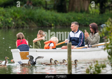 Petite famille dans une barque sur un lac en été au Royaume-Uni. Banque D'Images