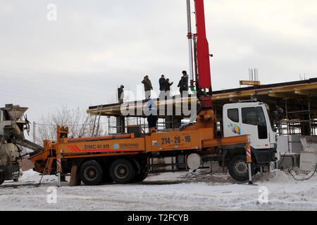 L'équipe de constructeurs travaillant sur la construction du bâtiment à Novossibirsk, dans l'hiver de béton coulé à l'aide d'une construction spéciale de la Banque D'Images