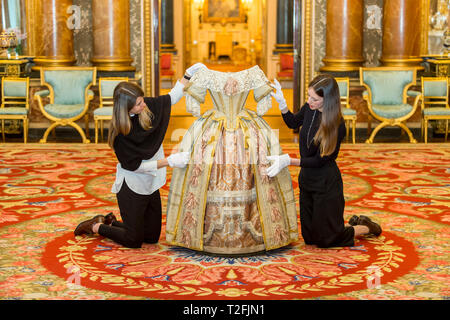 Londres, Royaume-Uni. 2 avril 2019. Les commissaires posent avec la reine Victoria's Stuart Ball costume. Aperçu de la reine Victoria 'Palace' exposition au Palais de Buckingham. A l'exposition marque le 200e anniversaire de la naissance de la reine Victoria (1819-1901) et de raconter l'histoire de ses 62 ans de règne et de sa vie au palais de Buckingham. Plus de 80 objets seront affichés dans le cadre de l'ouverture d'été de l'État Chambres 20 Juillet au 29 septembre 2019. Crédit : Stephen Chung / Alamy Live News Banque D'Images