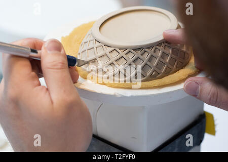 23 mars 2019, Basse-Saxe, Fürstenberg : un céramiste industriel travaille sur un panier en porcelaine dans les atelier de la manufacture de porcelaine de Fürstenberg. Photo : Swen Pförtner/dpa Banque D'Images