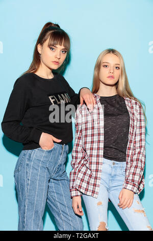 Nous sommes amis. Close up fashion portrait de deux jeunes filles hipster cool portant des jeans usés. Portrait de deux modèles ayant l'amusement et de sérieux Banque D'Images