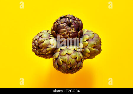 Groupe de 4 Artichauts isolées de ci-dessus sur un fond jaune concept flatlay Banque D'Images