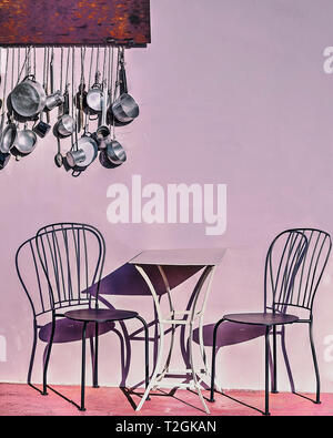 Une table et deux chaises avec des ombres en plein air . Cuisine casseroles suspendu dans l'arrière-plan. Image Banque D'Images