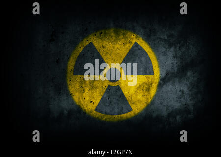 (Radioactive nucléaire atomique rayonnement ionisant) jaune d'avertissement de danger la forme des symboles peints sur le mur de ciment béton massif sombre texture grunge background Banque D'Images