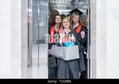 Kharkov, Ukraine - le 27 novembre 2018 : Groupe d'apprenants de sexe féminin dans des robes gaies avec des sacs dans l'ascenseur de l'université Banque D'Images