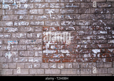 Vieux mur de briques de la maison avec le déchiré-off annonces. Banque D'Images