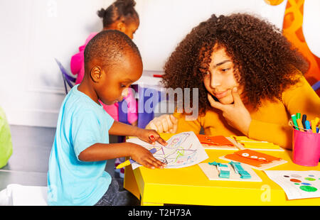 Petit garçon noir faisant des exercices de perfectionnement aux enseignants dans l'école maternelle Banque D'Images