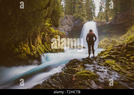 Femme en face d'une cascade, Sahalie Falls, Oregon, USA Banque D'Images