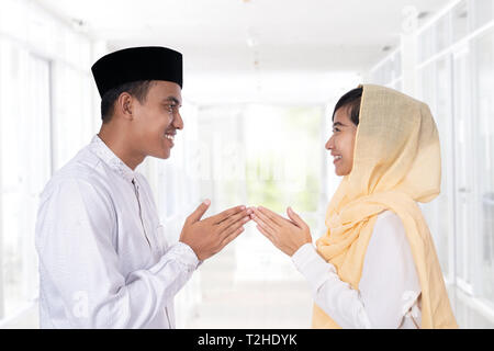 Toucher la main femme musulmane traditionnelle asiatique accueil célébration Eid Mubarak islamique Banque D'Images