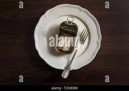 Les sardines en boîte sur une plaque blanche avec une fourchette, sur une table en bois, Allemagne Banque D'Images