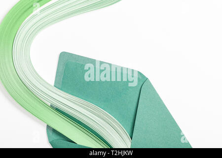 Close up of green enveloppe avec arc-en-ciel multicolores sur fond blanc Banque D'Images