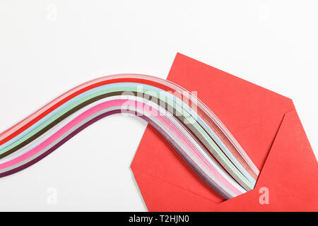 Close up of red enveloppe avec arc-en-ciel multicolores sur fond blanc Banque D'Images