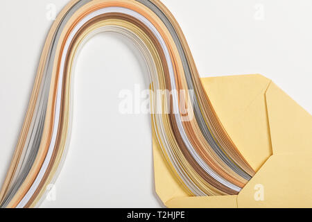 Close up of enveloppe jaune avec arc-en-ciel multicolores sur fond gris Banque D'Images
