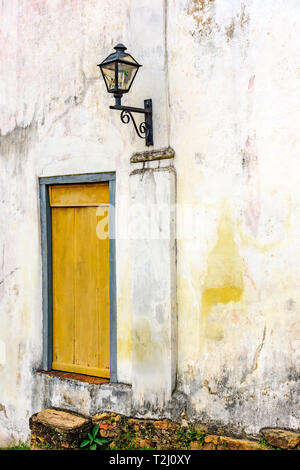 Ancienne Lanterne éclairage résidentiel à côté d'une fenêtre en bois anciente et âgés d'un vieux bâtiment à l'architecture coloniale dans la ville d'Ouro Preto à Minas Banque D'Images