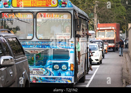 Galle, Sri Lanka - Février 18th, 2019 : un bus du Sri Lanka et un passager debout sur sa porte à Matara Road à Galle, au Sri Lanka. Banque D'Images