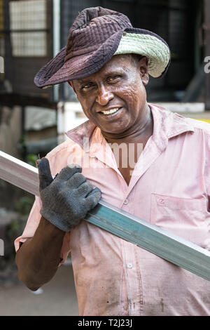 Galle, Sri Lanka - Février 18th, 2019 : Portrait d'un travailleur masculin, la tenue d'un profil en aluminium à Galle, au Sri Lanka. Banque D'Images