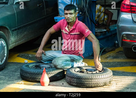 Galle, Sri Lanka - Février 18th, 2019 : un réparateur de pneus sri-lankais de gonfler un pneu à Galle, au Sri Lanka. Banque D'Images